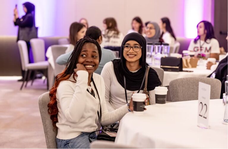 GEM Mentees watch a presentation at a table
