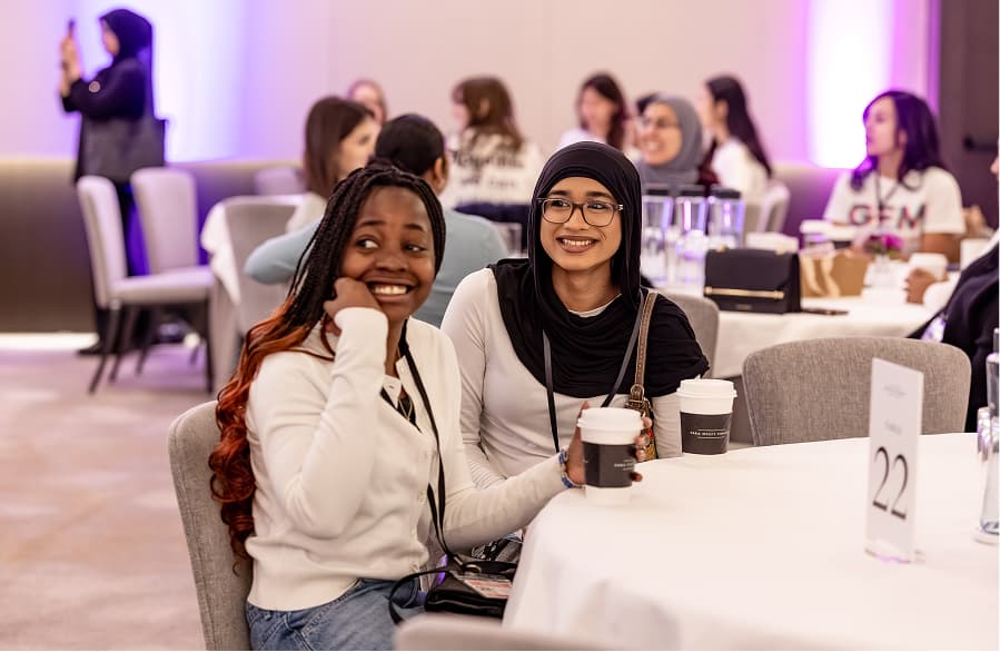 GEM Mentees watch a presentation at a table